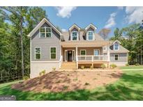 Charming two-story home features a welcoming front porch and a well-manicured lawn at 220 Nicklaus Cir, Social Circle, GA 30025