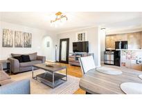 Cozy living room featuring a modern light fixture, hardwood floors, and comfortable seating area at 300 W Peachtree St # 10D, Atlanta, GA 30308
