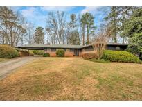 Charming single-story home with well-maintained landscaping and covered parking area at 1555 Moores Mill Nw Rd, Atlanta, GA 30327