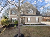 Charming two-story home with symmetrical windows, manicured lawn, and welcoming entrance at 6615 Grove Meadows Ln, Cumming, GA 30028