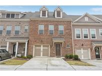 Charming brick townhome with a one-car garage and beautifully maintained front lawn at 1566 Ridgebrook Downs, Mableton, GA 30126