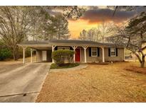 Charming single-story home featuring a covered carport, red front door, and well-maintained lawn at 3003 Landmark Dr, Conyers, GA 30094
