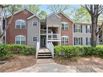 Charming condo building with brick and siding exterior, accented by well-maintained landscaping at 394 Teal Ct, Roswell, GA 30076