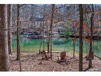 Beautiful lake view with private dock and seating area surrounded by trees at 6880 Nantucket Cv, Cumming, GA 30041