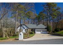 Charming ranch-style home with a two-car garage, well-maintained lawn, and mature trees at 1190 Saint Ives Ct, Suwanee, GA 30024