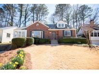 Charming brick home featuring a manicured lawn and lovely landscaping at 1251 Cumberland Ne Rd, Atlanta, GA 30306
