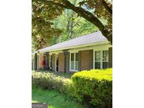 Charming brick home with decorative iron porch posts and mature landscaping at 3415 Lake Carlton Rd, Loganville, GA 30052