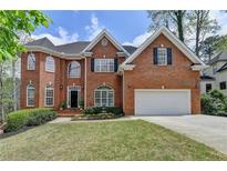 Charming two-story brick home with a well-manicured lawn and attached two-car garage at 525 Water Shadow Ln, Alpharetta, GA 30022