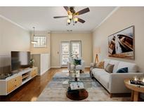 Bright living room with a ceiling fan, decorous rug, and a sliding glass door to the outside patio at 1536 Liberty Nw Pkwy, Atlanta, GA 30318