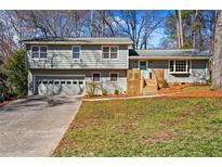 Charming split-level home featuring a garage, a welcoming front yard, and a light-blue painted front door at 5403 Woodberry Cir, Marietta, GA 30068