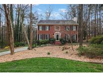 Charming brick home with a landscaped front yard nestled among mature trees at 3266 Bruckner Blvd, Snellville, GA 30078