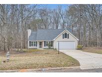 Charming single-Gathering home with well-maintained landscaping, neutral siding, and an attached two-car garage at 1493 Buckeye Ter, Auburn, GA 30011