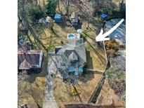 Aerial view of home featuring a pool, parking, mature trees, and nice sized yard at 1608 Carroll Nw Dr, Atlanta, GA 30318