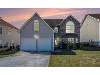 Charming home with a two-car garage, stone accents, and manicured front lawn at 11643 Sarah Loop, Hampton, GA 30228