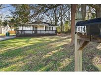 Charming single-story home with a spacious front deck and well-maintained lawn at 1414 Pierce Se Ave, Smyrna, GA 30080