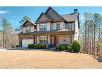 Charming two-story home with stone accents, manicured landscaping, and a welcoming front porch at 702 Ridgeway Ct, Canton, GA 30114