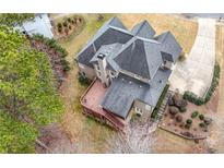 Stunning aerial view of a house featuring a deck, manicured landscaping, and a long driveway at 925 Sentry Ridge Xing, Suwanee, GA 30024