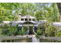 Beautiful home exterior with stone accents, mature trees, and unique architectural details at 385 Grimes Bridge Rd, Roswell, GA 30075