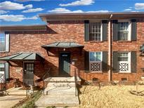 Charming brick townhome with black shutters and covered entryway offers classic curb appeal at 5676 Kingsport Dr # 4, Atlanta, GA 30342