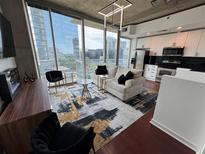 Bright condo living room featuring modern lighting, dark hardwood floors, and sweeping city views at 3324 Peachtree Ne Rd # 1115, Atlanta, GA 30326