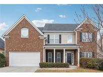 Charming two-story home with a brick facade, a well-manicured lawn, and an attached two-car garage at 5932 Vinings Vintage Way, Mableton, GA 30126