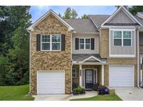 Charming townhome showcasing brick facade, front lawn and attached single-car garage at 10166 Benton Woods Dr, Covington, GA 30014