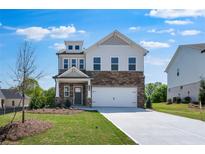Charming two-story home featuring stone accents, a two-car garage, and a well-manicured front lawn at 1420 Windance Lake Dr, Loganville, GA 30052
