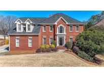 Beautiful two-story brick home with a meticulously landscaped front yard and elegant architectural details at 1774 Harrogate Ct, Grayson, GA 30017