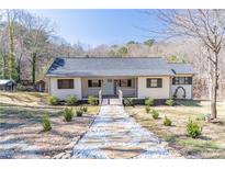 Charming home featuring a welcoming front porch, tidy landscaping, and a stone walkway leading to the entrance at 3465 Callie Still Rd, Lawrenceville, GA 30045