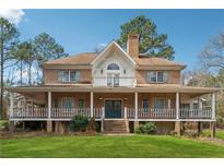 Charming two-story brick home with a welcoming wrap-around porch and mature landscaping at 2200 Gleneagle Nw Ct, Conyers, GA 30012