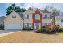 Charming two-story home with a brick accent, manicured lawn, and attached two-car garage at 1042 Wildwood Wake Bnd, Dacula, GA 30019