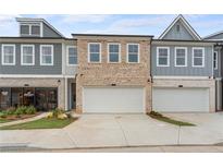 Beautiful townhome exterior featuring brick and siding with a two-car garage and modern architectural details at 1024 Rose Dr, Marietta, GA 30060