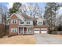 Charming two-story brick home with a well-manicured front yard and a two-car garage at 69 New Brunswick Ct, Suwanee, GA 30024