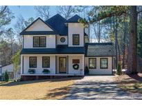 Charming two-story home with white siding, black trim, and a well-manicured lawn, offering classic curb appeal at 8404 Majors Rd, Cumming, GA 30041