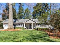 Charming single-story home featuring a well-manicured lawn and traditional architectural details at 436 Carolwood Ln, Atlanta, GA 30342