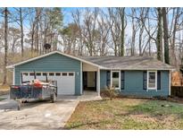 Charming one-story home featuring an attached garage, well-maintained lawn, and inviting curb appeal at 815 Oxford Hall Dr, Lawrenceville, GA 30044