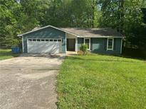 Charming single-story home featuring an attached garage and a well-maintained lawn at 815 Oxford Hall Dr, Lawrenceville, GA 30044