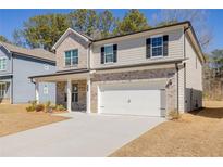 Charming two-story home featuring a brick and siding exterior, two-car garage and well-manicured lawn at 325 Caledonia Court Ct, Peachtree City, GA 30269