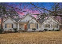 Charming single Gathering home with red front door and white painted wood facade and dark shutters at 9369 Kraft Dr, Winston, GA 30187