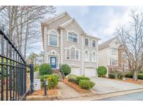 Charming two-story home featuring detailed architectural trim, arched windows, attached garage, and well-maintained landscaping at 2426 Vivian Cir, Decatur, GA 30030