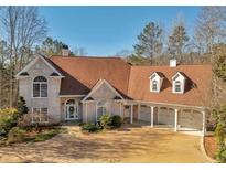 Charming two-story brick home with a three-car carport and well-maintained landscaping at 3460 Mansions Pkwy, Berkeley Lake, GA 30096