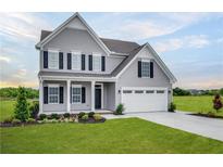 Charming two-story home with gray siding, black shutters, two car garage and well-manicured lawn at , Mcdonough, GA 30253