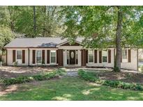 Charming single-story home with white brick, brown trim, well-manicured lawn, and inviting front entrance at 4159 King Valley Se Dr, Smyrna, GA 30082