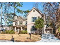Charming two-story home with neutral siding, stone accents, a red door, and a detached single-car garage at 2217 Virginia Ne Pl, Atlanta, GA 30305