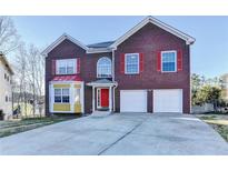 Charming two-story brick home with a two-car garage and a vibrant red front door at 4270 Fallbrook Dr, Duluth, GA 30096