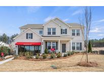 Beautiful two-story home with manicured lawn, brick accents, covered porch, and professionally landscaped front yard at 5955 Misty Hill Ln, Buford, GA 30518