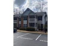 Two-story condo with balcony, brick facade, and designated resident parking at 124 Streamside Dr # 24, Roswell, GA 30076