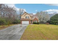 Charming two-story home featuring a brick and tan siding facade, attached garage, and well-manicured lawn at 381 Gates Mil Dr, Lawrenceville, GA 30045