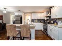 Modern kitchen featuring white cabinets, stainless steel appliances, and a stylish backsplash at 3224 Canary Ct, Decatur, GA 30032