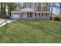 Charming single-story brick home with a manicured lawn and inviting front porch in a wooded neighborhood at 2350 Brenda Se Dr, Smyrna, GA 30080